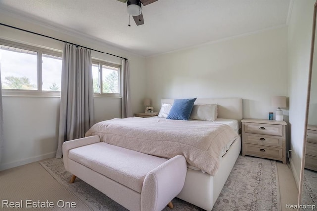 bedroom featuring crown molding, a ceiling fan, baseboards, and light colored carpet