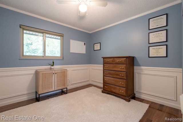 unfurnished office with crown molding, ceiling fan, and dark wood-type flooring