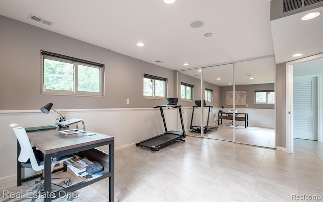 exercise room featuring baseboards, visible vents, and a healthy amount of sunlight