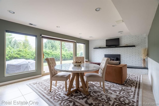 tiled dining space featuring visible vents, recessed lighting, and a brick fireplace