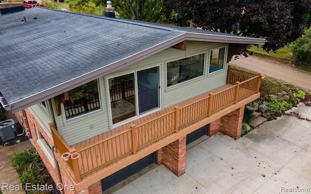 exterior space featuring roof with shingles and central AC unit