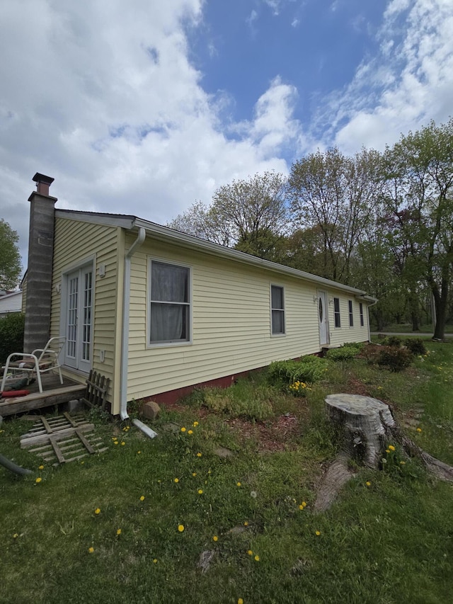 view of property exterior with french doors, a chimney, and a deck