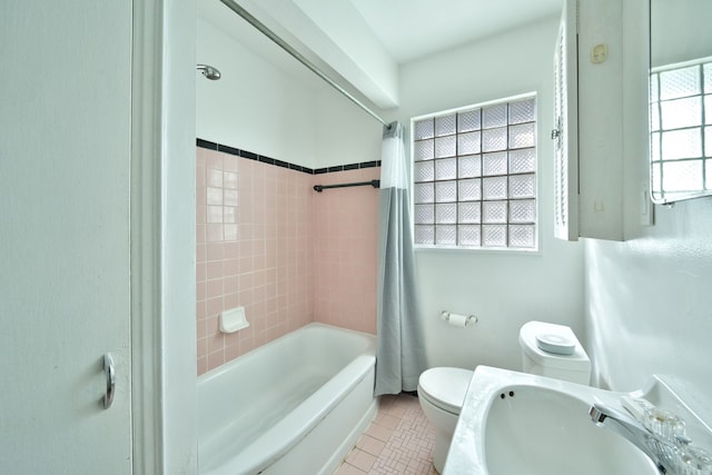 bathroom with a sink, tile patterned flooring, toilet, and shower / bath combination with curtain