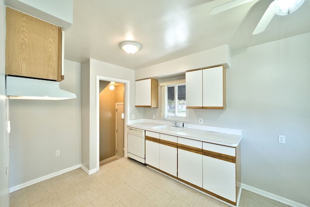 kitchen with white dishwasher, a sink, light countertops, white cabinets, and baseboards