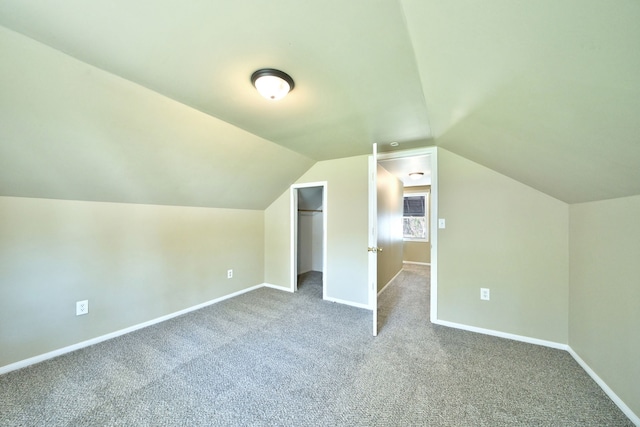 additional living space featuring carpet, baseboards, and lofted ceiling