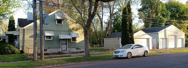 view of front of home featuring an outbuilding, board and batten siding, a garage, and fence