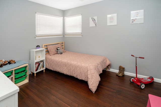 bedroom with wood-type flooring and baseboards