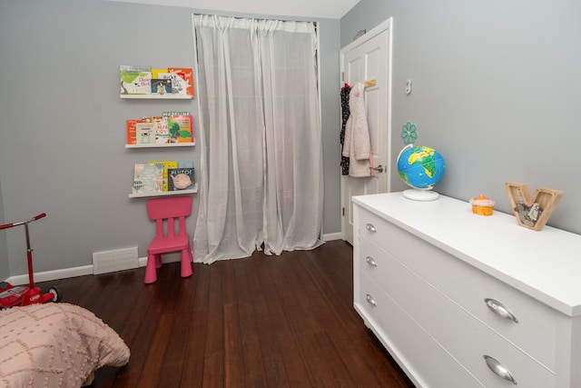 bedroom with baseboards, visible vents, and dark wood finished floors