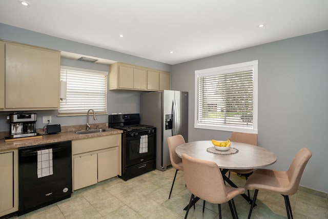 kitchen featuring recessed lighting, a sink, black appliances, and cream cabinets