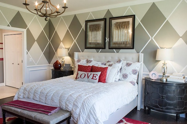 bedroom featuring crown molding, a decorative wall, and a notable chandelier