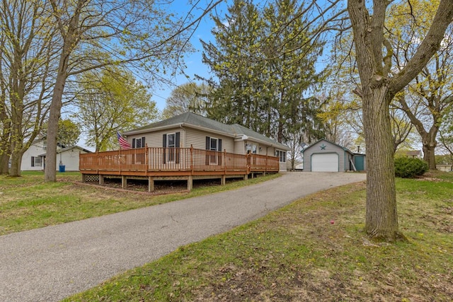 view of front of property with an outdoor structure, a front lawn, aphalt driveway, and a wooden deck