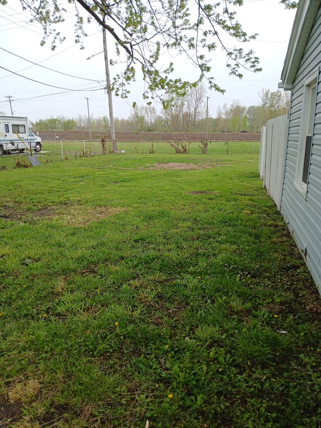 view of yard featuring fence and a rural view