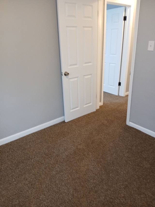 spare room featuring baseboards and carpet floors