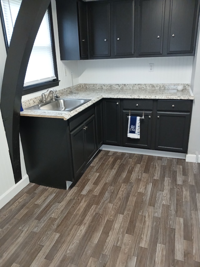kitchen with a sink, dark wood-type flooring, and dark cabinets