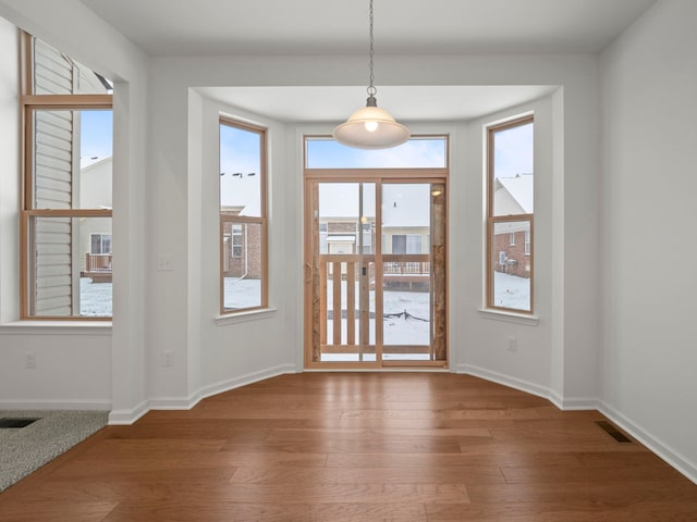 interior space featuring baseboards, visible vents, and hardwood / wood-style flooring