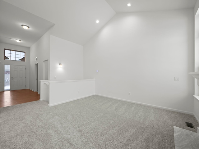 carpeted empty room with baseboards, recessed lighting, visible vents, and high vaulted ceiling