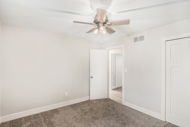 785 Maple Dr, Columbiaville, MI 48421 - unfurnished bedroom featuring baseboards, a ceiling fan, dark colored carpet, and visible vents