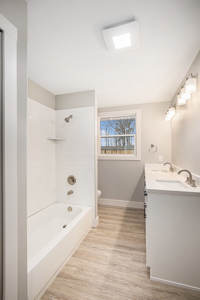 785 Maple Dr, Columbiaville, MI 48421 - bathroom with double vanity, toilet, wood finished floors, a sink, and baseboards