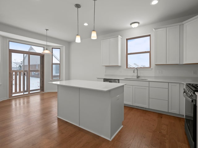 kitchen with a sink, black range, a kitchen island, and light countertops