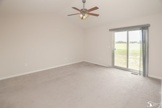 empty room featuring ceiling fan, light colored carpet, baseboards, vaulted ceiling, and visible vents