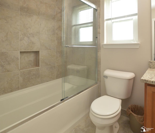full bathroom featuring vanity, toilet, and shower / bath combination with glass door