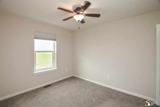 spare room featuring carpet floors, baseboards, a ceiling fan, and visible vents