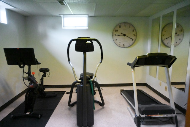 workout area with carpet, a drop ceiling, and baseboards