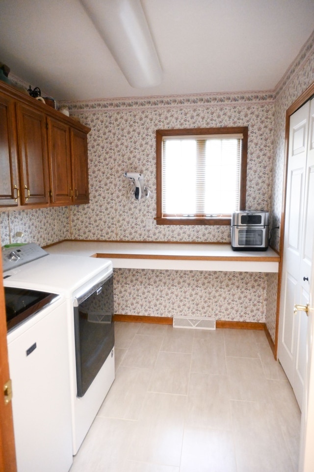 laundry area featuring cabinet space, visible vents, washing machine and clothes dryer, light tile patterned floors, and wallpapered walls
