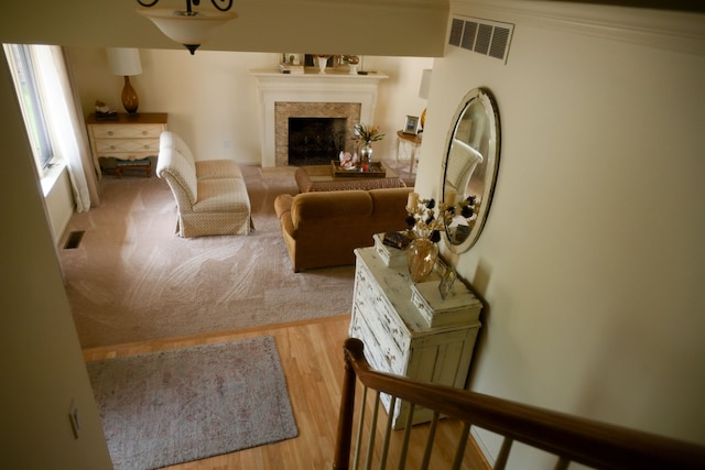 living area with a fireplace, visible vents, and wood finished floors