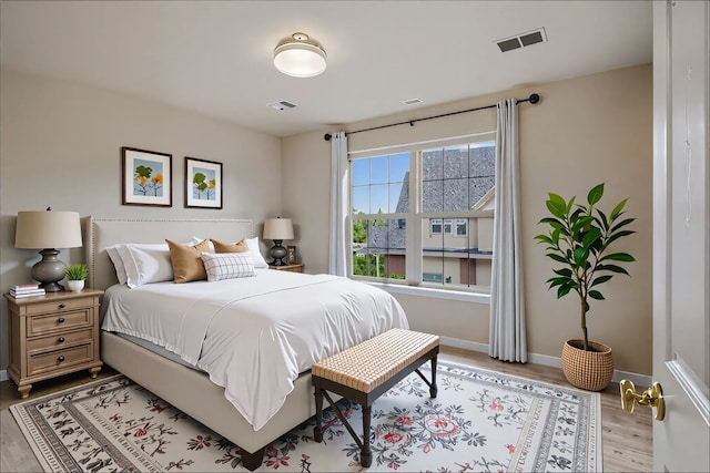bedroom featuring visible vents, wood finished floors, and baseboards