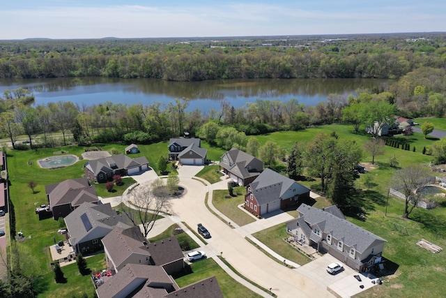 drone / aerial view featuring a water view, a residential view, and a wooded view