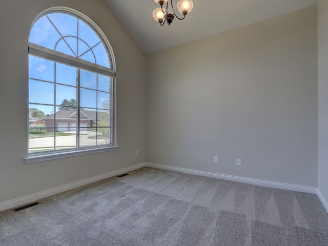 spare room with a notable chandelier, visible vents, carpet floors, baseboards, and vaulted ceiling