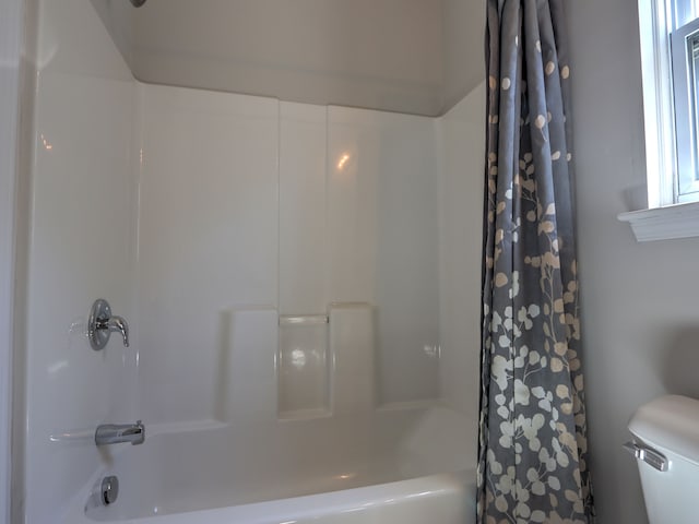 bathroom featuring toilet and shower / bath combination with curtain