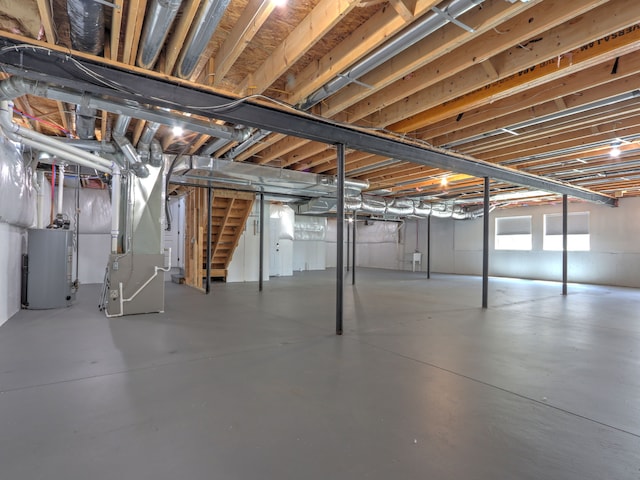 below grade area featuring stairs, heating unit, and water heater