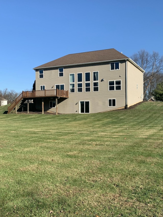 rear view of property with a wooden deck and a yard