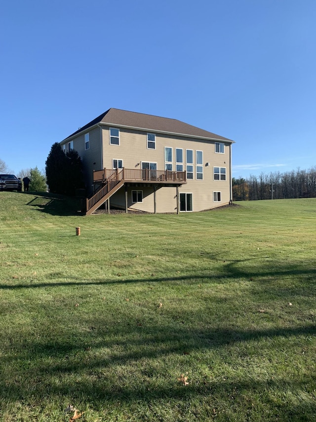 back of property featuring stairs, a yard, and a deck