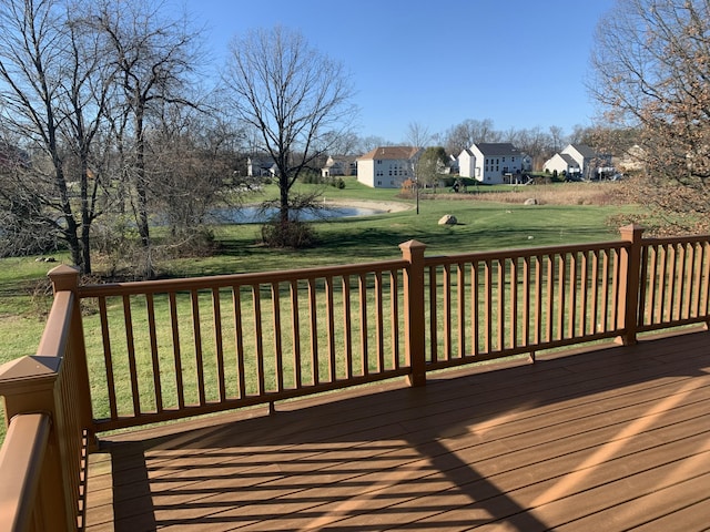 wooden terrace featuring a lawn and a residential view