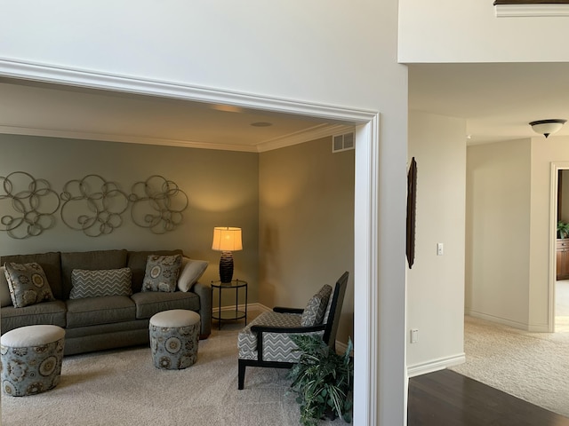 carpeted living room featuring visible vents, ornamental molding, and baseboards