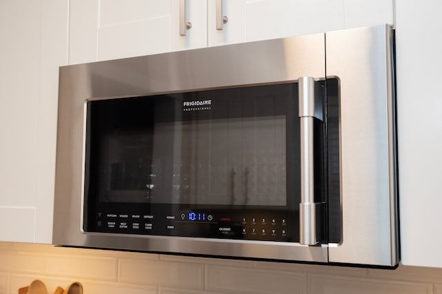 interior details with white cabinetry and stainless steel microwave