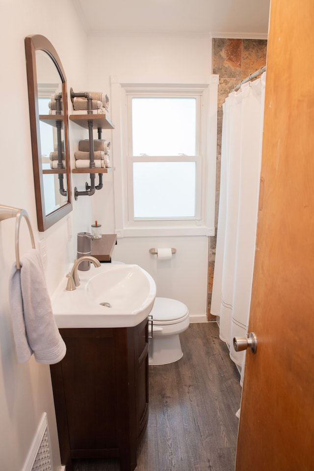full bathroom featuring toilet, a shower with curtain, wood finished floors, vanity, and visible vents