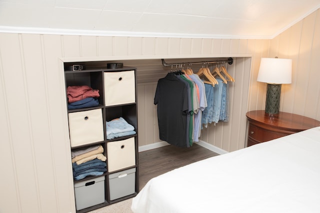 bedroom with crown molding, wood finished floors, and baseboards