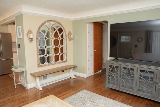 interior space featuring ornamental molding, baseboards, arched walkways, and wood finished floors