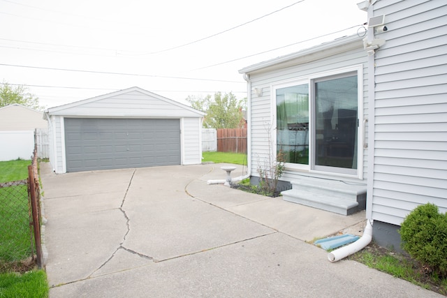 exterior space featuring an outdoor structure, fence, and a detached garage