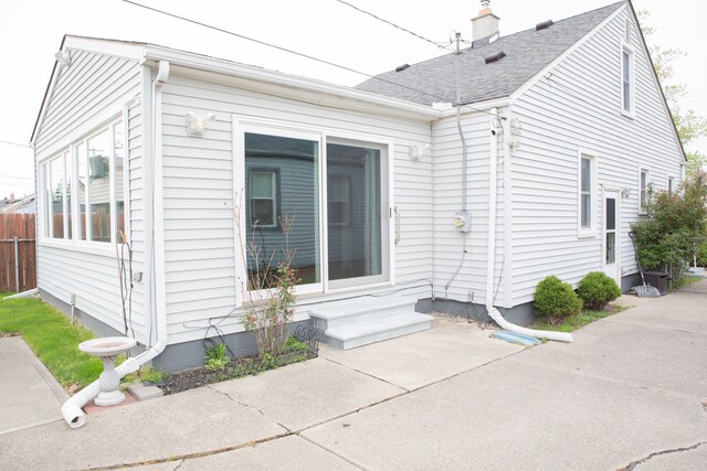 exterior space featuring a shingled roof and fence