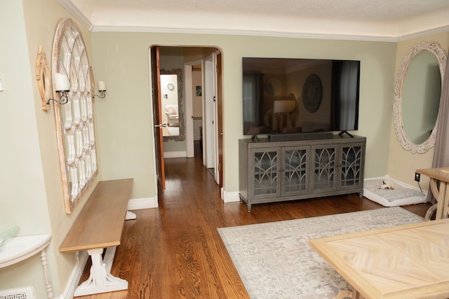 corridor featuring ornamental molding, baseboards, and wood finished floors