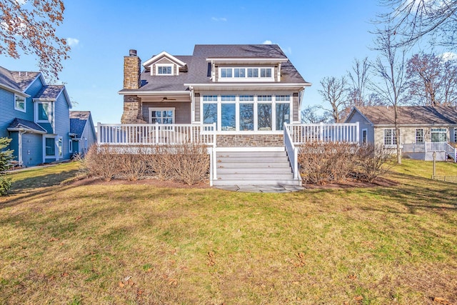 back of house with a lawn, a wooden deck, and a chimney
