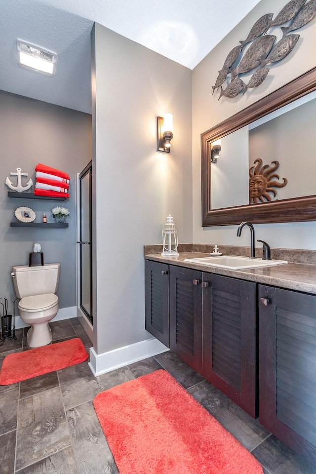 full bathroom featuring vanity, toilet, baseboards, a shower stall, and visible vents
