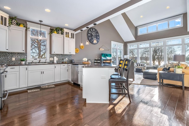 kitchen with a healthy amount of sunlight, a breakfast bar, a peninsula, and open floor plan