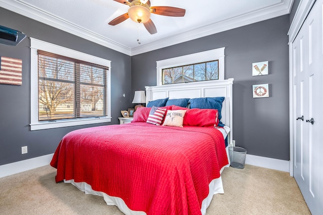 bedroom with a ceiling fan, baseboards, a closet, ornamental molding, and carpet