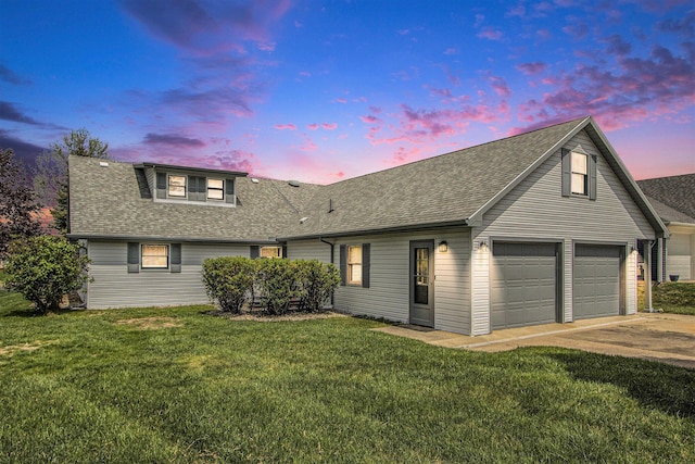 view of front of home featuring a lawn, a shingled roof, and concrete driveway